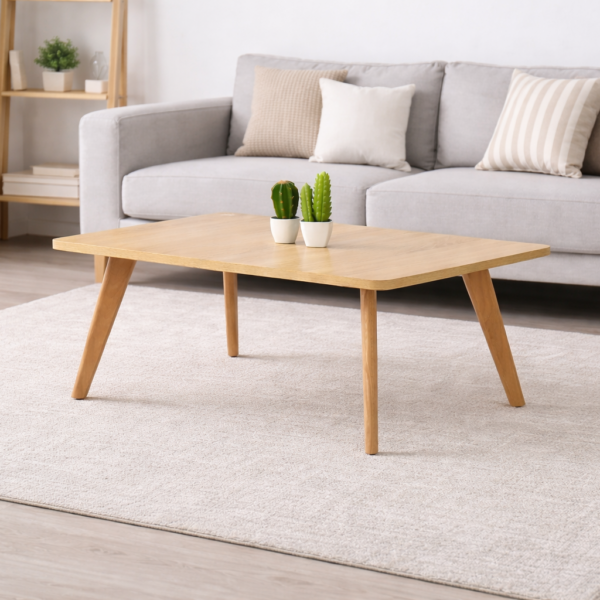 Table basse rectangulaire en bois clair avec pieds en bois naturel, intégrée dans un salon moderne avec canapé gris et tapis clair.
