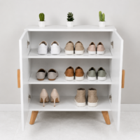 Meuble de rangement blanc style scandinave à deux portes avec poignées et pieds en bois naturel, idéal pour salon, entrée ou chambre.