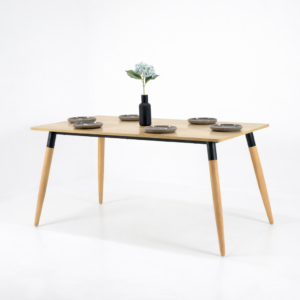 Table à manger rectangulaire moderne avec plateau bois clair en MDF et pieds en bois naturel et métal noir, décor minimaliste sur fond blanc.
