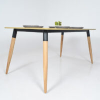 Table à manger scandinave moderne avec plateau en bois clair et pieds en bois naturel et métal noir, intégrée dans un décor intérieur simple et lumineux.