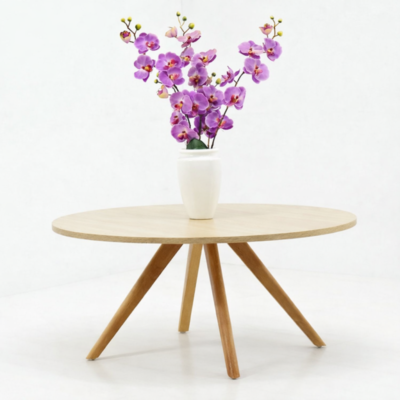 Table basse ronde en bois naturel avec pieds inclinés de style scandinave, posée dans un décor minimaliste blanc