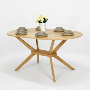 Table à manger ronde en bois naturel avec pied central sculpté, présentée sur fond blanc avec vaisselle décorative