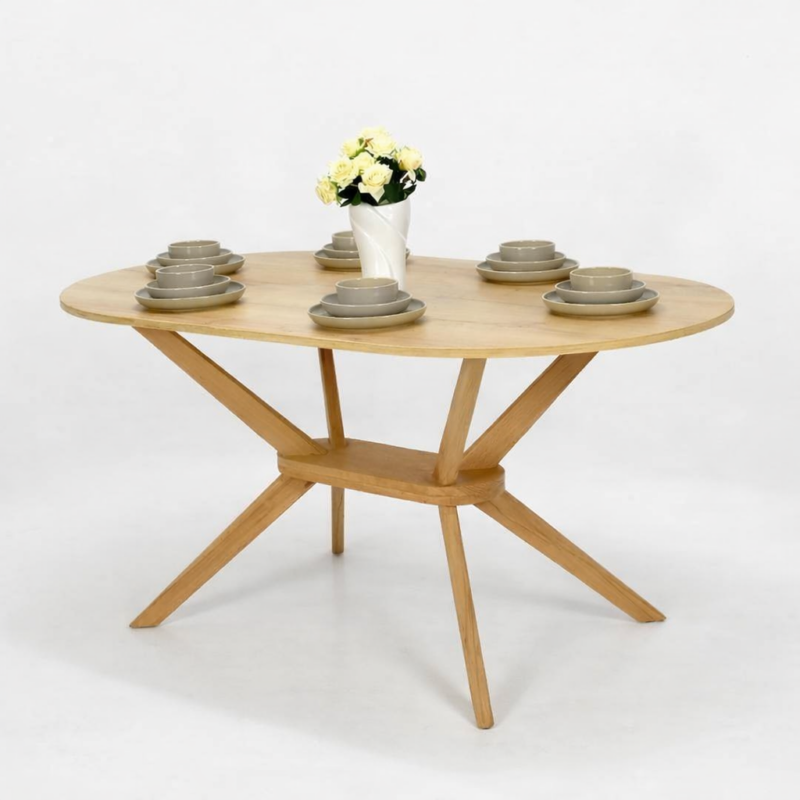 Table à manger ronde en bois naturel avec pied central sculpté, présentée sur fond blanc avec vaisselle décorative