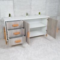 Buffet scandinave blanc avec portes effet bois clair, tiroirs de rangement et pieds en bois naturel sur fond blanc minimaliste.