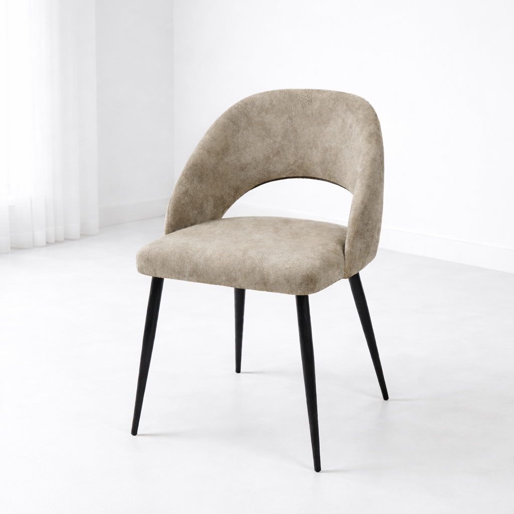 Chaise moderne en tissu beige avec dossier arrondi et pieds en métal noir dans un décor simple et épuré
