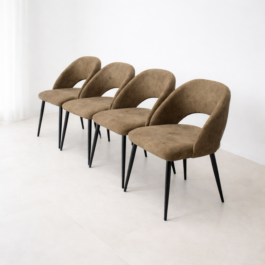 Lot de quatre chaises modernes marron en tissu suédé avec pieds noirs, présentées dans un décor minimaliste épuré