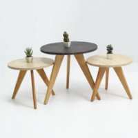 Ensemble de trois tables basses gigognes rondes en bois naturel avec pieds inclinés, style scandinave minimaliste, sur fond blanc
