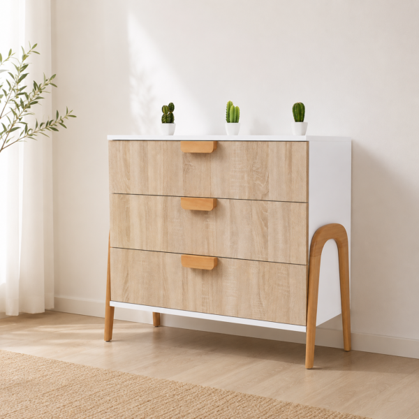 Commode scandinave 3 tiroirs en bois clair et blanc intégrée dans une décoration minimaliste moderne et lumineuse.
