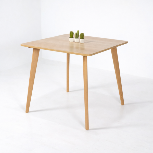 Table à manger carrée design scandinave avec plateau bois clair et pieds en bois naturel, présentée sur fond blanc retouché.