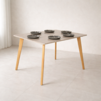 Table à manger carrée design scandinave en bois clair, mise en situation dans un décor naturel minimaliste sans chaises, avec vaisselle et éléments décoratifs.