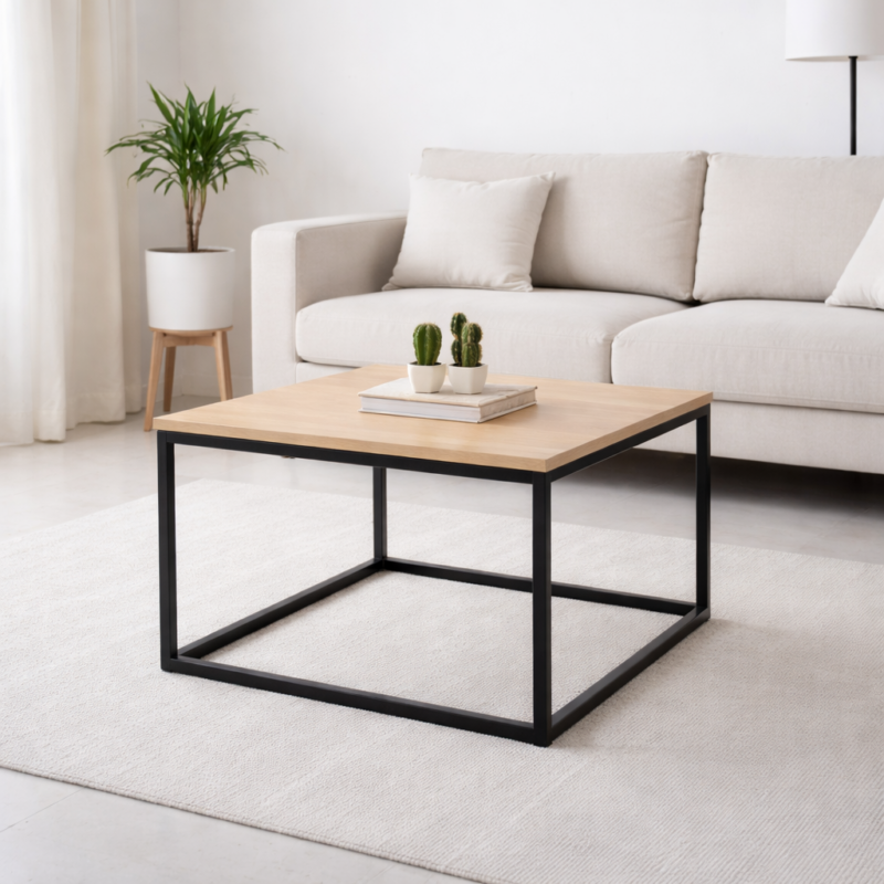 Table basse carrée moderne avec plateau en bois clair et structure en métal noir, intégrée dans un salon minimaliste lumineux.