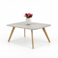 Table basse carrée en bois clair avec pieds en bois naturel, photographiée sur fond blanc avec vase décoratif.