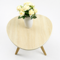 Table basse ronde en bois clair avec pieds inclinés, style scandinave minimaliste pour salon moderne et lumineux