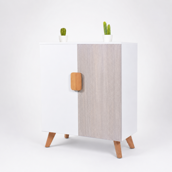 Meuble de rangement scandinave blanc et chêne gris clair avec pieds et poignée en bois, présenté sur fond blanc dégradé gris clair.