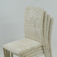 Chaises empilables recouvertes de tissu bouclette clair au design moderne, présentées sur fond blanc