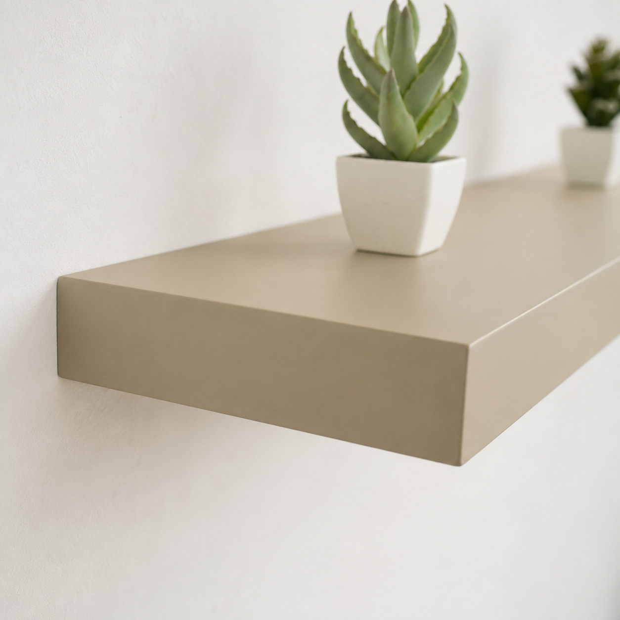 Étagère murale flottante beige fixée sur un mur blanc avec décoration minimaliste, idéale pour salon, chambre ou bureau.