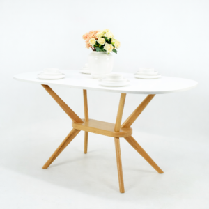 Table à manger ovale avec plateau blanc et pieds en bois naturel, présentée sur fond blanc avec décoration florale