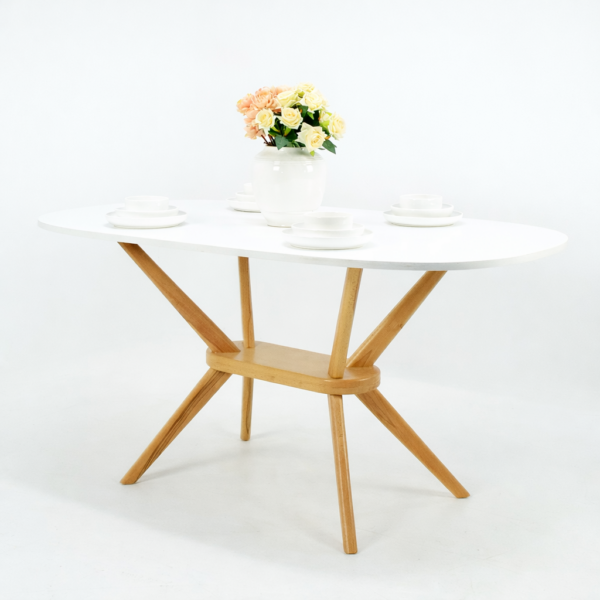 Table à manger ovale avec plateau blanc et pieds en bois naturel, présentée sur fond blanc avec décoration florale