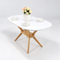 Table à manger ovale avec plateau blanc et pieds en bois naturel, intégrée dans un décor intérieur simple et assorti sans chaises