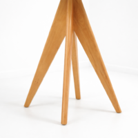 Table à manger scandinave blanche avec plateau carré et pieds en bois naturel, présentée sur fond blanc avec un design moderne et minimaliste.