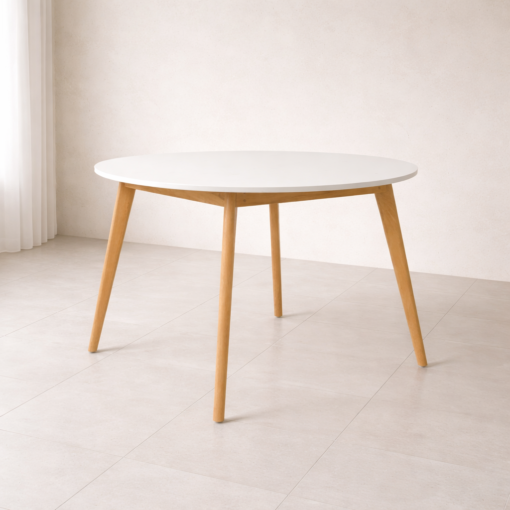Table ronde design scandinave avec plateau blanc et pieds en bois naturel intégrée dans un décor intérieur minimaliste et lumineux, sans chaises.