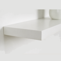 Étagère murale flottante blanche dans un décor minimaliste beige avec vase décoratif et fleurs.