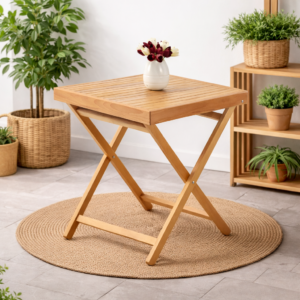 Table pliante carrée en bois massif avec plateau à lattes, intégrée dans un décor naturel et minimaliste avec plantes décoratives.