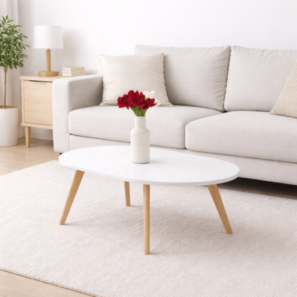 Table basse blanche design scandinave avec pieds en bois naturel, intégrée dans un salon moderne et lumineux.