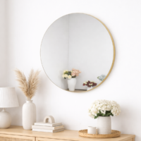 Miroir rond mural avec cadre fin doré installé sur un mur blanc, design moderne et minimaliste pour salon ou chambre.