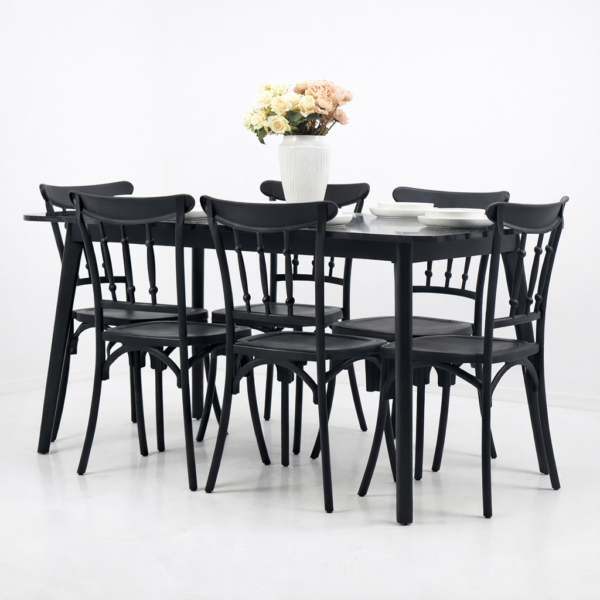 Salle à manger contemporaine avec table rectangulaire noire effet marbre et six chaises noires, décor minimaliste avec vase de fleurs sur la table.