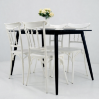 Table à manger noire effet marbre avec quatre chaises blanches dans une salle à manger moderne au mur beige et sol en bois clair