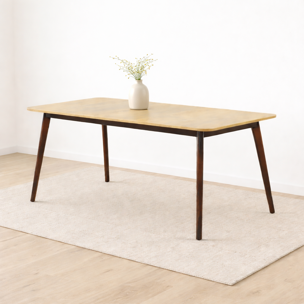 Table à manger en bois clair avec pieds foncés et vase décoratif sur tapis dans un décor minimaliste