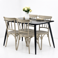 Table à manger moderne noire effet marbre avec quatre chaises beige et vase décoratif avec fleurs sur fond blanc