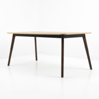Table à manger rectangulaire en bois clair avec pieds inclinés foncés sur fond blanc épuré
