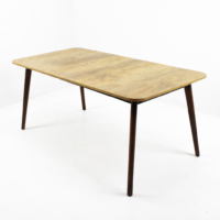Table à manger rectangulaire en bois clair avec pieds inclinés foncés sur fond blanc épuré
