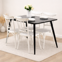 Table à manger moderne avec plateau noir effet marbre et chaises blanches dans un décor minimaliste avec tapis beige et sol en bois clair