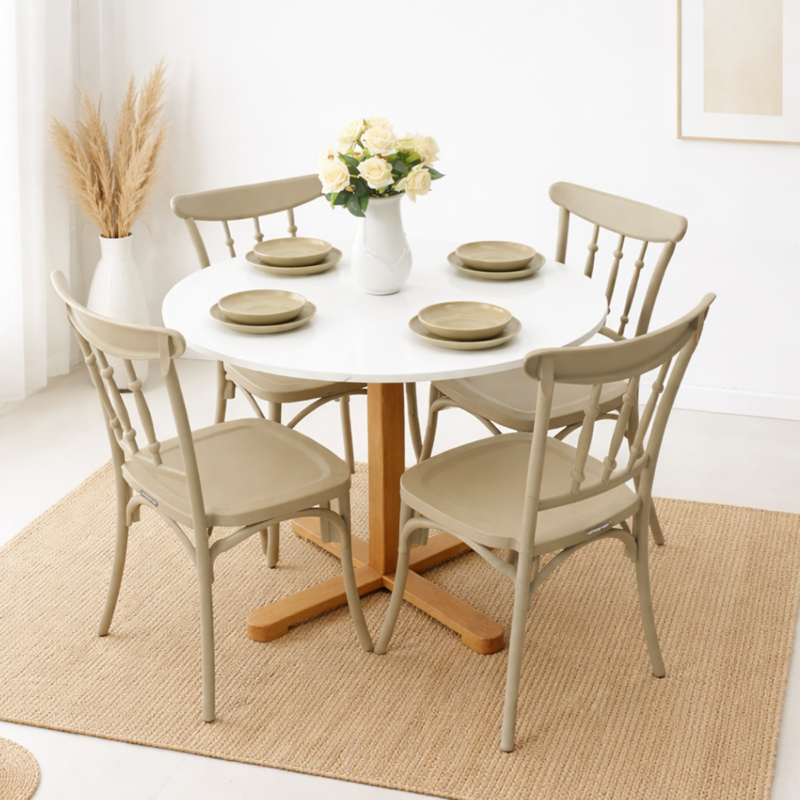 Table à manger ronde blanche avec quatre chaises beiges, posée sur un tapis en fibres naturelles dans un décor simple et lumineux avec vase décoratif