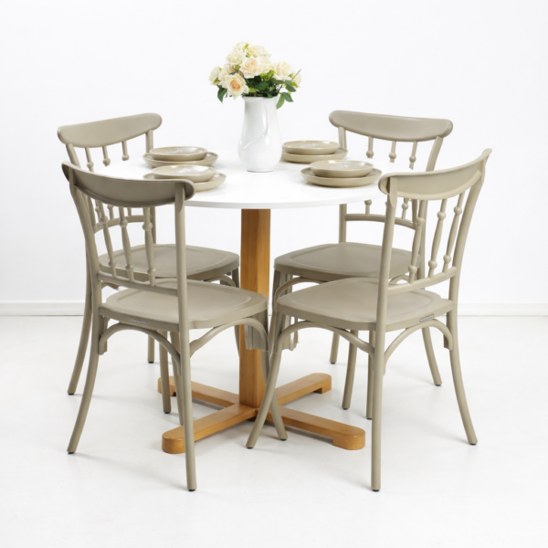 Table à manger ronde blanche avec pieds en bois et quatre chaises beiges, dressée avec vaisselle et vase de fleurs sur fond blanc