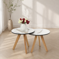 Deux tables basses gigognes rondes effet marbre avec pieds en bois dans un décor minimaliste lumineux