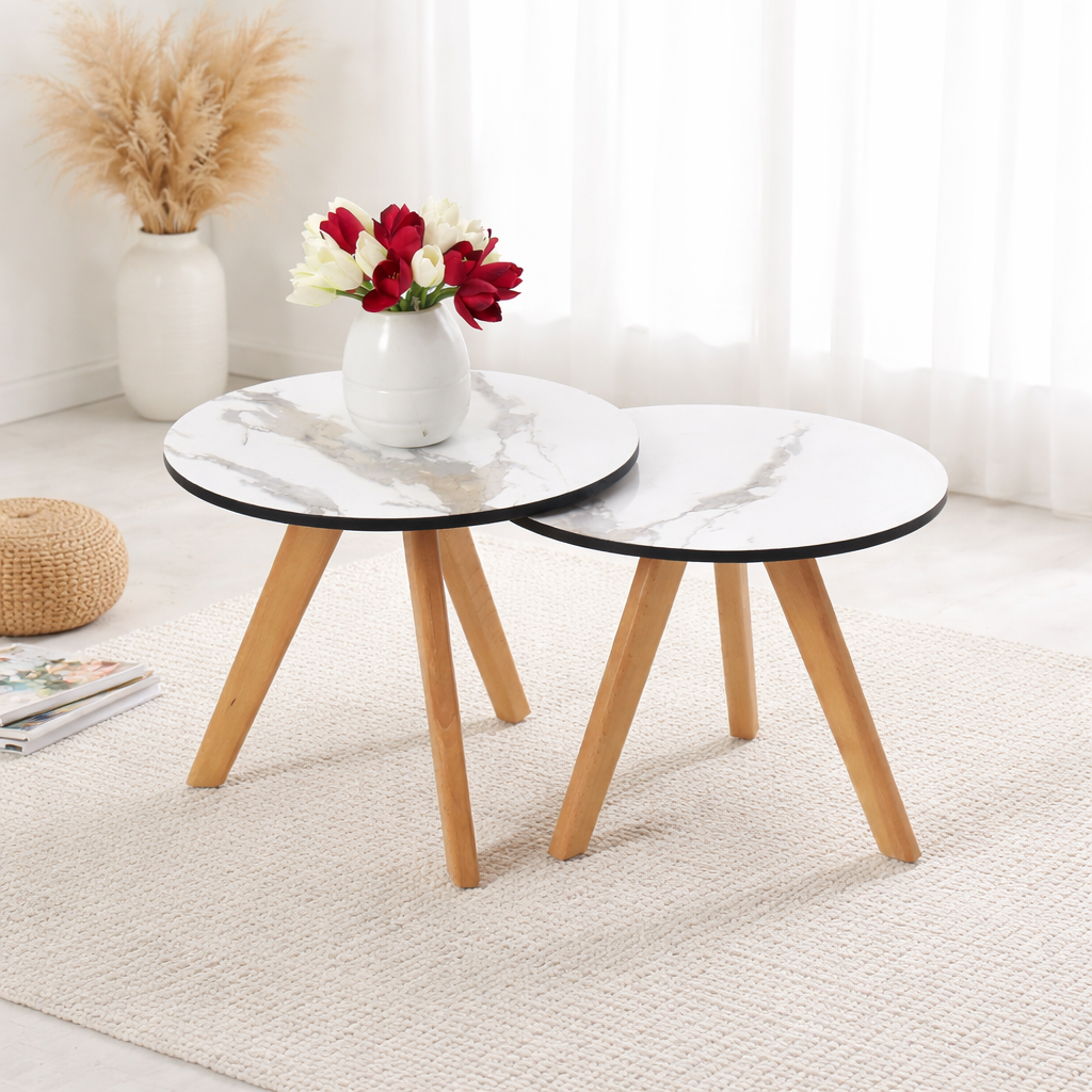 Deux tables basses gigognes rondes effet marbre avec pieds en bois dans un décor minimaliste lumineux