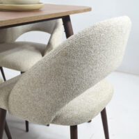 Table à manger moderne en bois foncé accompagnée de 6 chaises bouclées crème dans un style contemporain élégant.