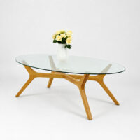 Table basse ovale avec plateau en verre trempé transparent et structure en bois massif au design scandinave, idéale pour un salon moderne.