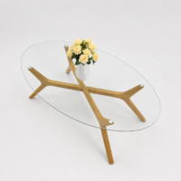 Table basse ovale avec plateau en verre trempé transparent et structure en bois massif au design scandinave, idéale pour un salon moderne.