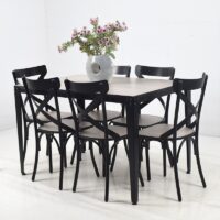 Ensemble salle à manger composé d'une table rectangulaire avec plateau effet bois clair et six chaises noires au design croisé, idéal pour une salle à manger moderne.