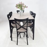 Ensemble salle à manger composé d'une table rectangulaire avec plateau effet bois clair et six chaises noires au design croisé, idéal pour une salle à manger moderne.